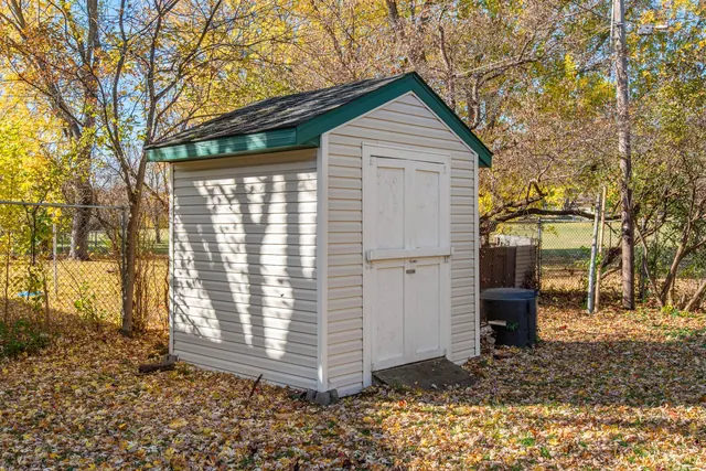 A quaint backyard shed surrounded by autumn foliage, ideal for storage solutions.