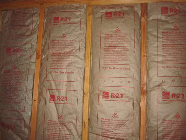 Installed faced fiberglass batt insulation with visible R-value. Batt, foam or board: comparing studio insulation systems on upkeep