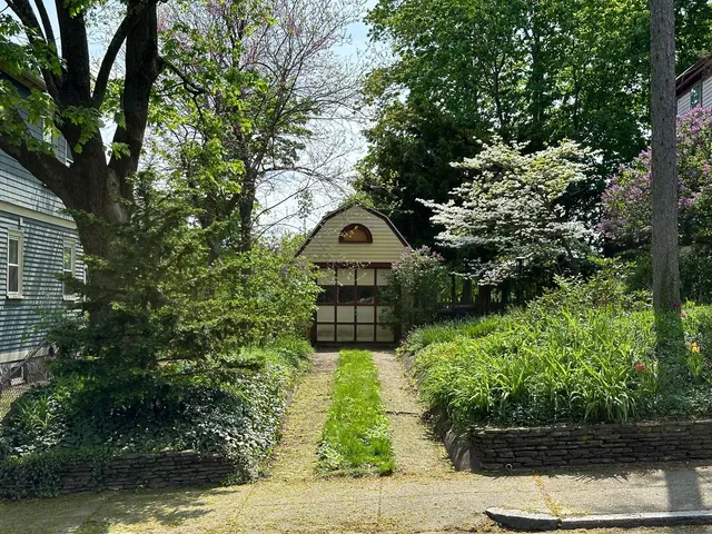 Beautiful garden path leading to a quaint shed surrounded by vibrant greenery.